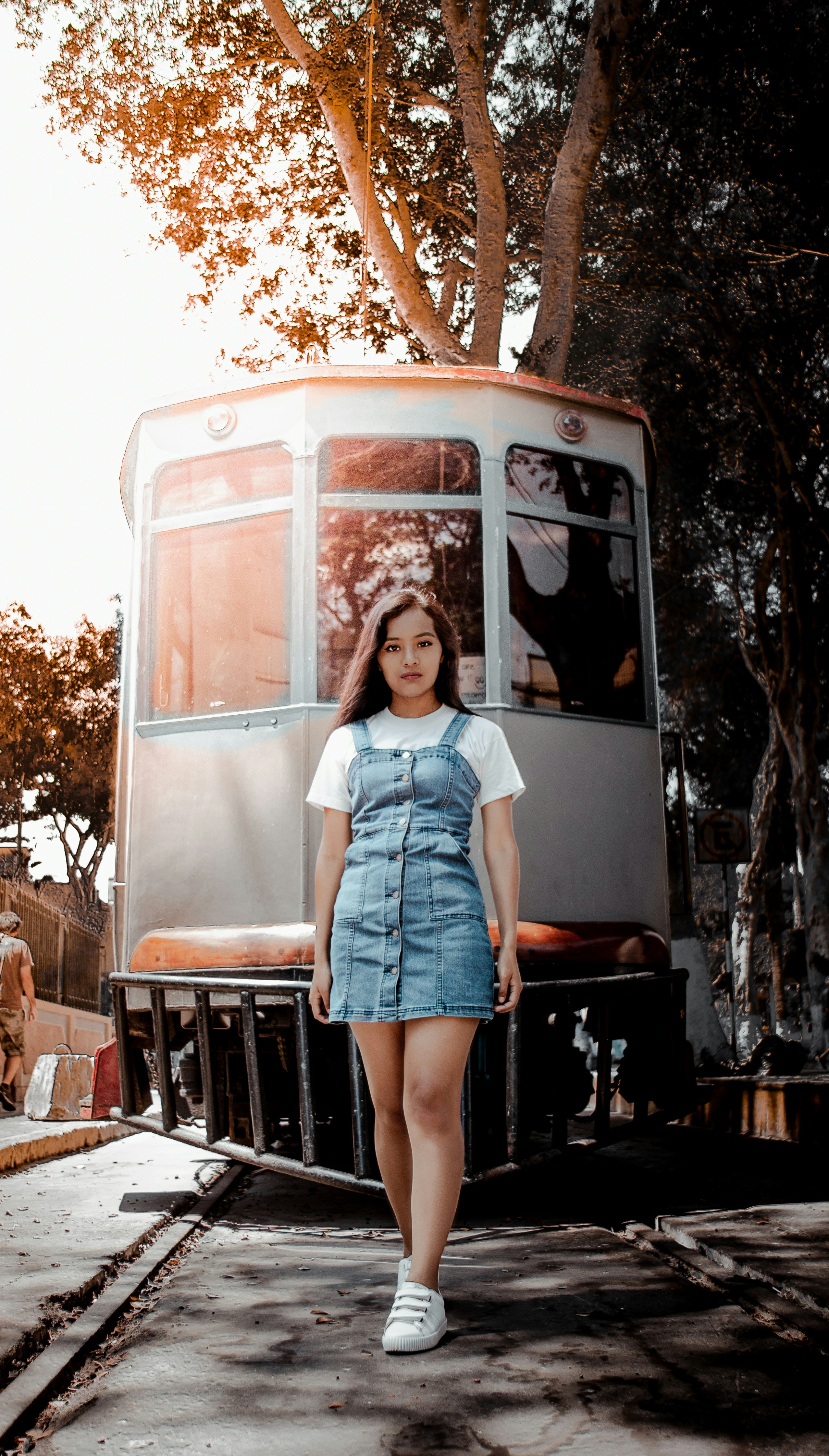 woman in denim overalls at the front of a train